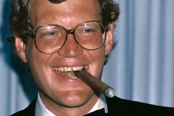 Young-David-Letterman-wearing-large-retro-eyeglasses-and-suit-whilst-smoking-a-cigar