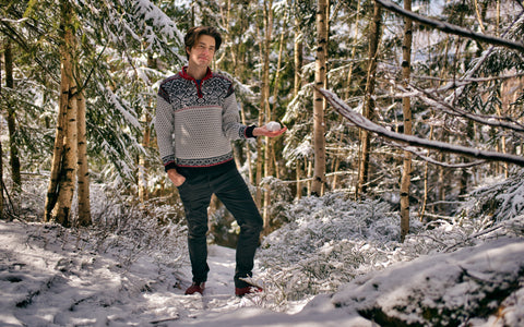 Muž v barefoot botách stojí v zimní krajině a usmívá se