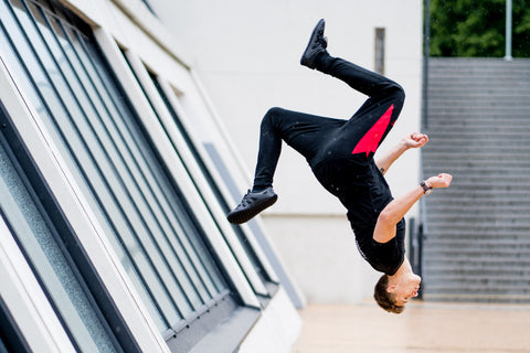 Muž v barefoot botách dělá salto.