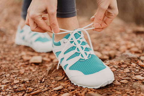 žena zavazující její Ahinsa Shoes Chitra Trek & Trail barefoot obuv