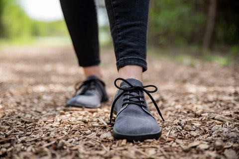 Žena v barefoot polobotkách Ahinsa shoes kráčí po přírodní cestě