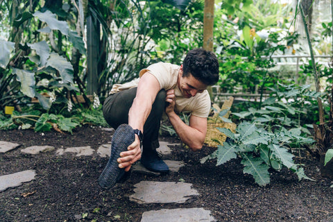 muž ve sportovním oblečení a barefoot botách se protahuje