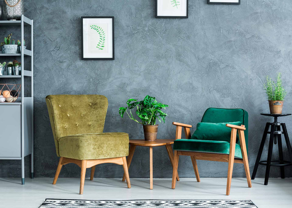 room with textured blue wallpaper, yellow chair, blue chair, and table with green plant