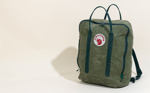 Classic green Fjällräven Kånken backpack isolated on a light background, showcasing its minimalist design