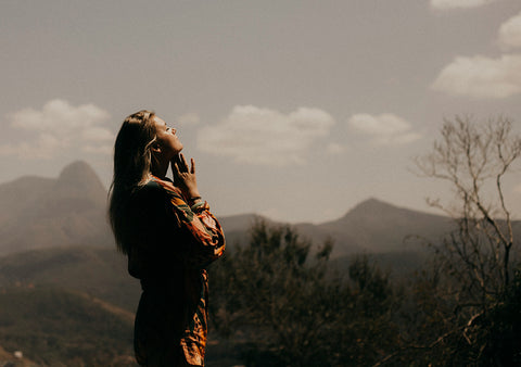 Woman at peace in nature with sun on her face