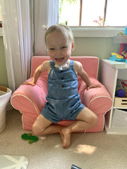 toddler lily sitting in pink kids chair