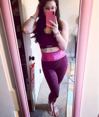 woman taking mirror selfie wearing a hot pink insulin pump belt