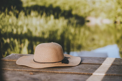Brown straw hat on a wooden bench outdoors