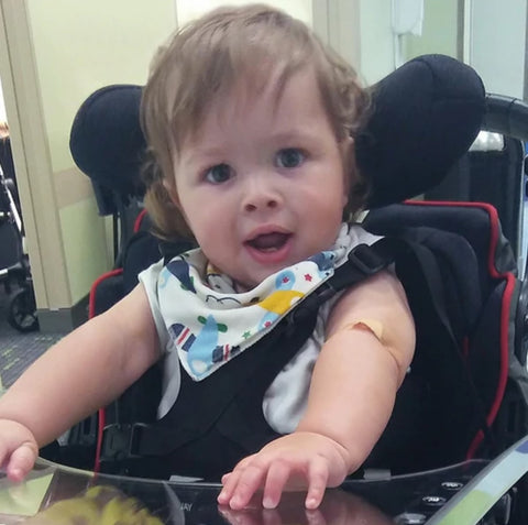 Toddler boy in a black chair with tray