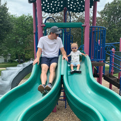 toddler lily on green slide with father