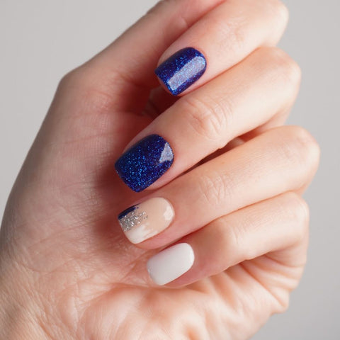 Korte vierkante nagels in wit met blauwe glitter