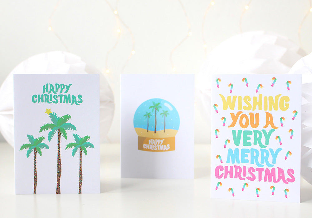 Image of three tropical Christmas cards standing beside each other