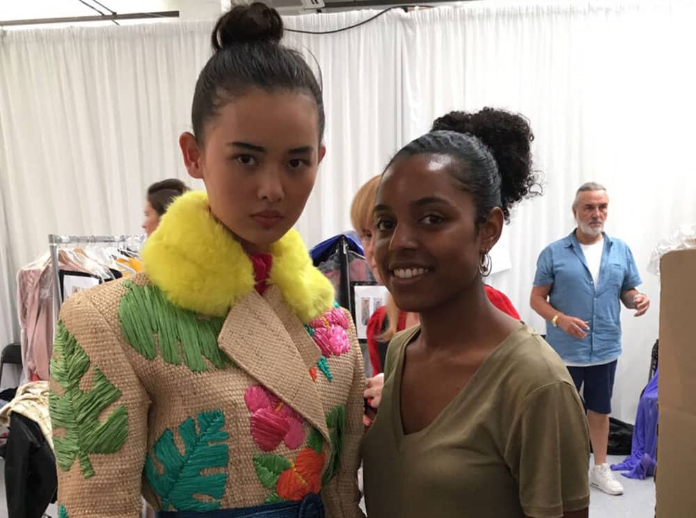 Designer - Tihara Smith with one of the models wearing one of the Windrush Collection pieces at Graduate Fashion Week