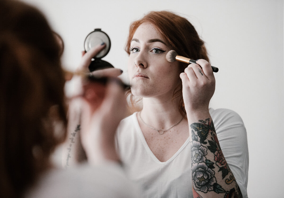 Freckled women putting on makeup