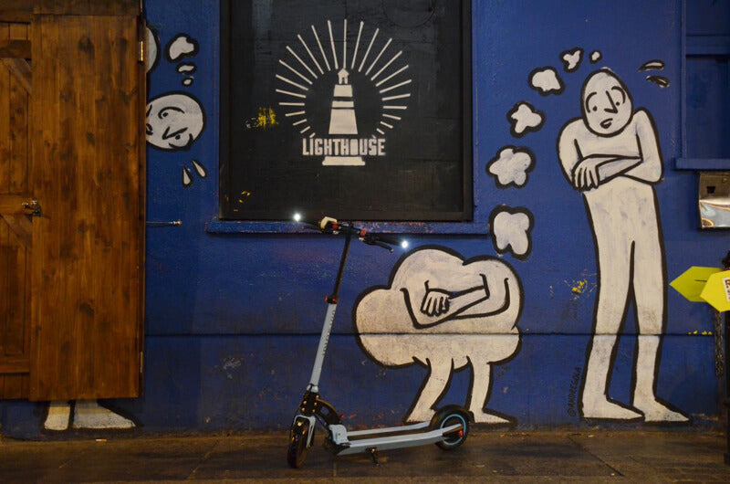 Scooter électrique devant des peintures murales