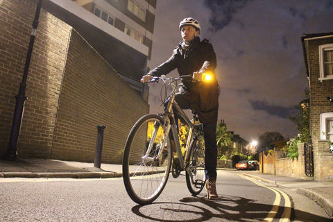 Man on a bicycle in the dark with WingLights turn signals and position lights on