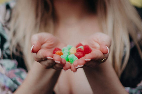 A female is holding a pile of Vegan CBD gumdrops in her hands