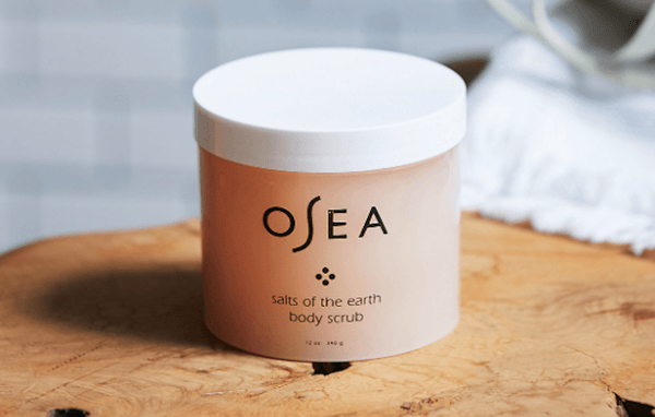 Osea's body scrub sits on a wooden stool