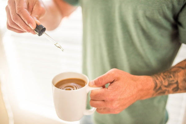 A man drops Sunday Scaries CBD Oil in his coffee to avoid the jitters
