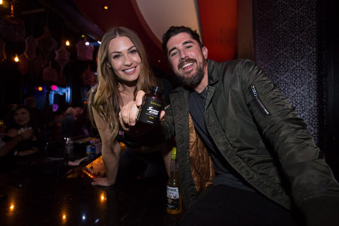 A boyfriend and his girlfriend are having fun hanging together at a bar.