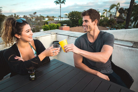 A man and woman cheers on a rooftop while on a date