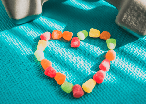 Sunday Scaries Vegan AF gummies are laid out in a heart shape on a yoga mat
