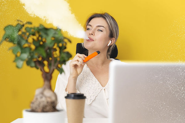 An image of a woman at her desk with a vape pen vaporizing THCA so it converts to THC