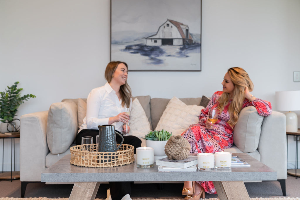 Two ladies sat chatting together on a sofa