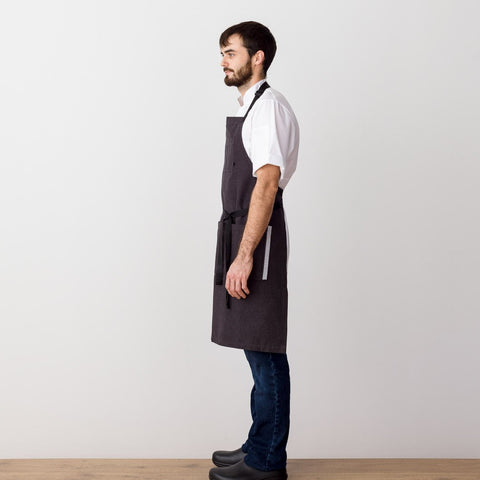 https://cdn.shopify.com/s/files/1/0523/1289/products/chefs-apron-charcoal-with-black-straps-men-or-women-textiles-the-reluctant-trading-experiment-3_large.jpg?v=1595598437