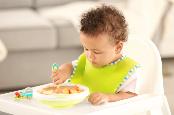 Baby feeding himself with a spoon