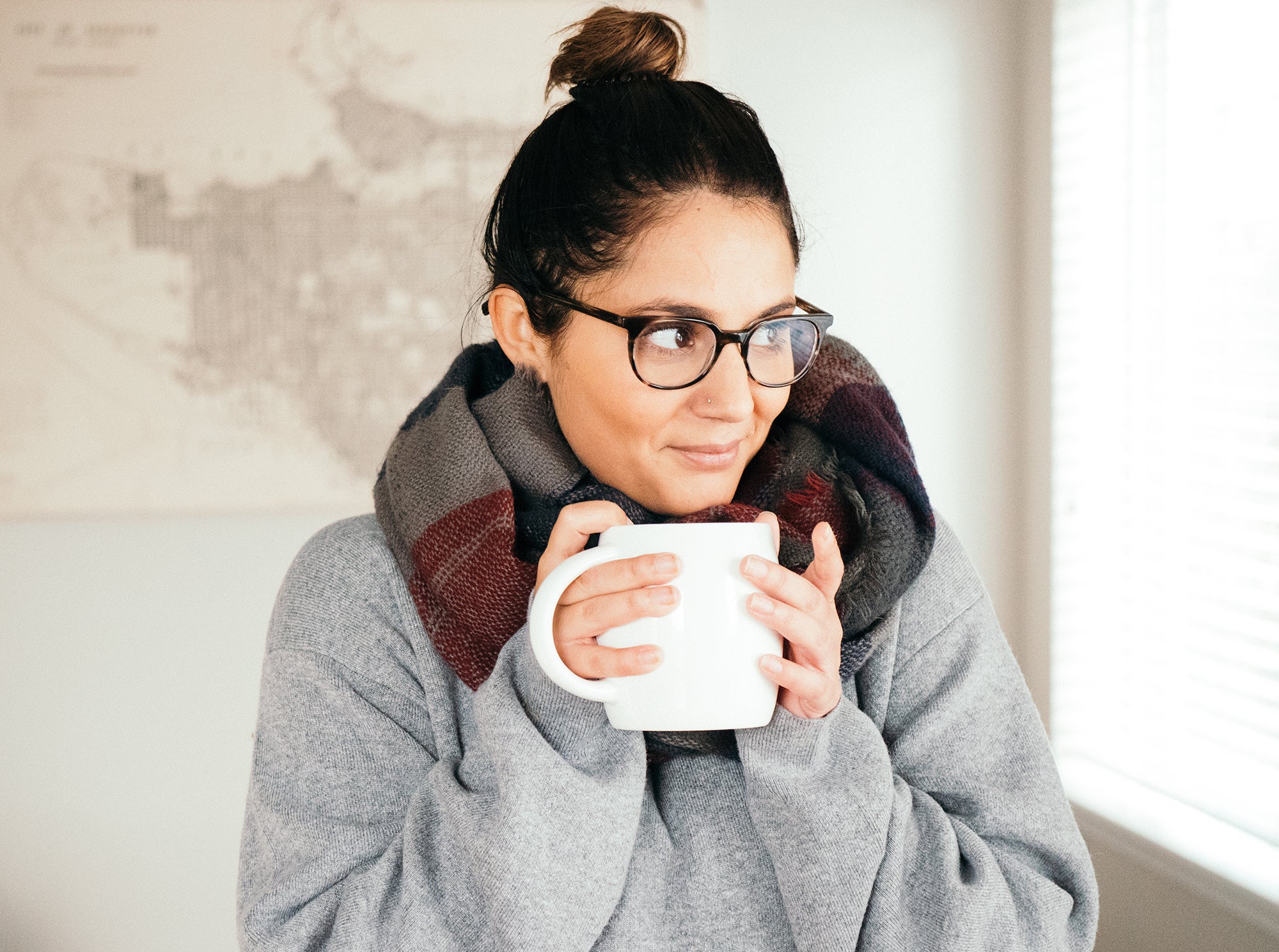 A person drinking Nuun from a mug wearing cozy clothing