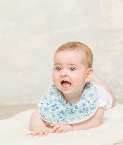 Bebé-con-babero-impermeable-de-flores-azules-de-la-marca-Gabis
