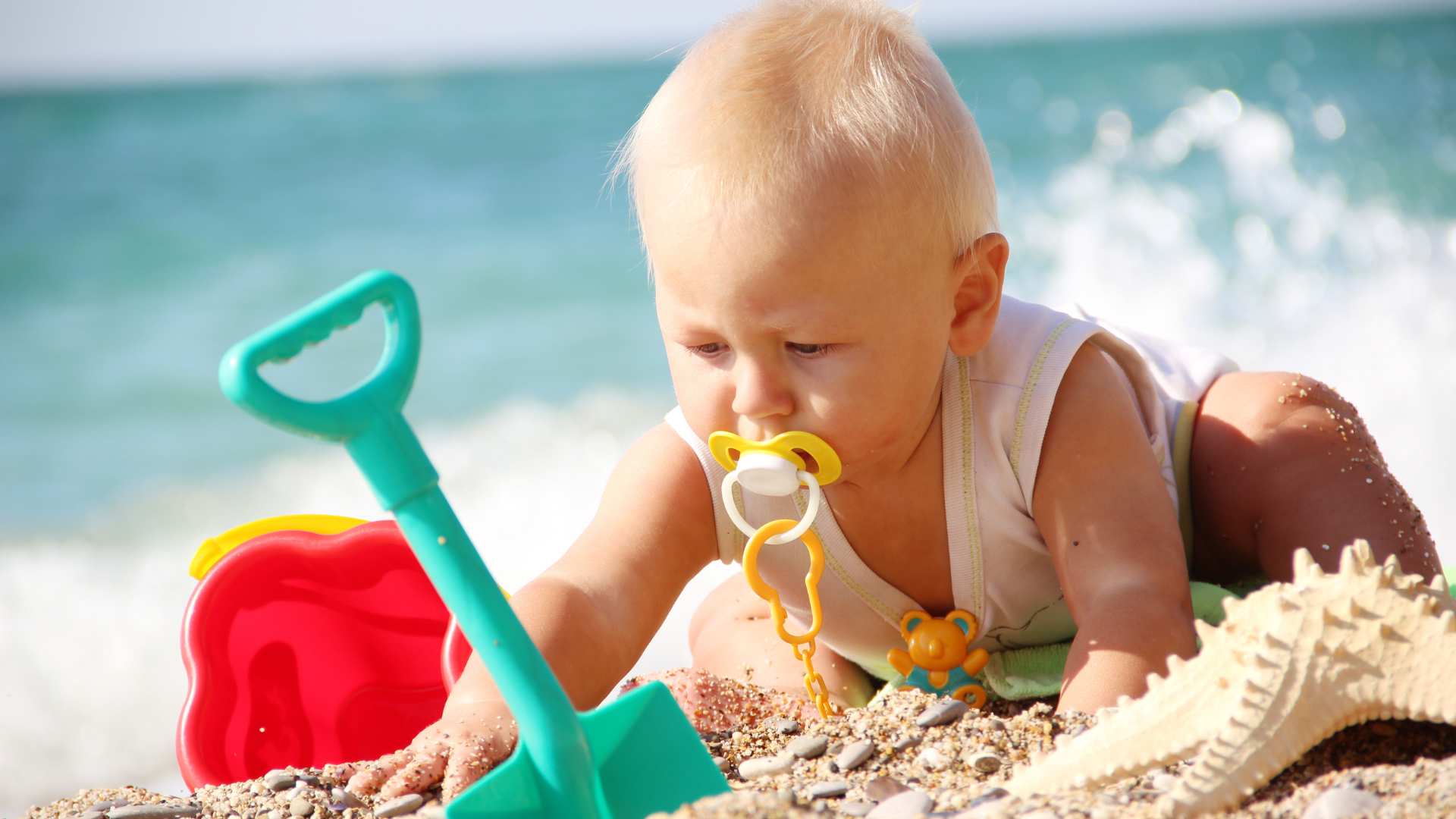 bebé jugando arena playa