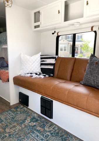Camper renovation living room makeover with new faux leather futon converted to trailer couch