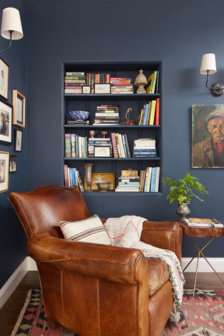 Dark gray blue walls of reading nook with leather chair