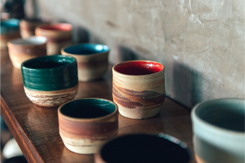 Artisanal handmade pottery on wooden shelf