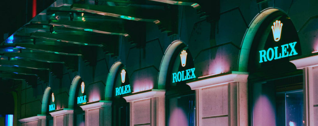A brightly lit storefront with a Rolex logo and banner