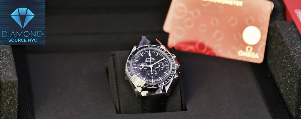 Open watch box showcasing an Omega Speedmaster and its warranty card
