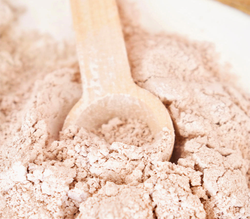 water free dry australian pink clay mask wooden spoon close up