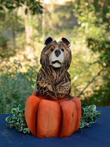 Bear in Pumpking Chainsaw Carved wood sculpture. halloween theme home decor. Seasonal decorations for home, office, business, indoor and outdoor accents. adorable bear carving with painted orange pumpkin by Artist Jess Alice