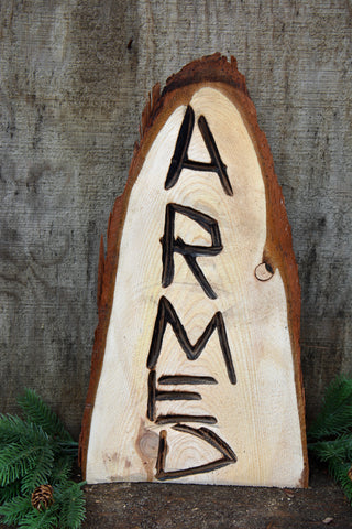 Funny "Armed" wood chainsaw carved wood sculpture made from California Cedar. by Artist Jess Alice perfect for front porch sign to make guests laugh. Great gift idea