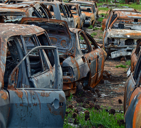 Junk Yard Photograph by Artist Jess Alice depicts the devastation from Dixie Fire in California and the remains of burned, metal, cars in a junk yard left from the wildfire