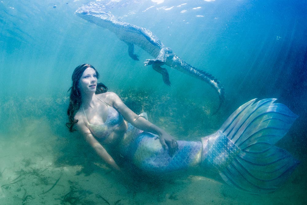 Meerjungfrau schwimmt mit Krokodil