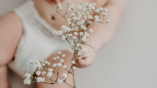 baby holding flowers, natural ingredients