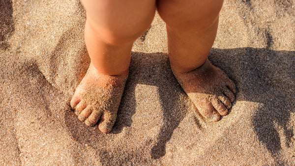 baby feet in sand during summer