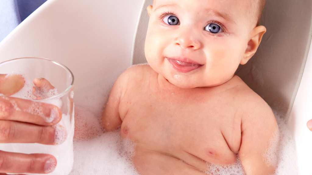 parent bathing baby in bath