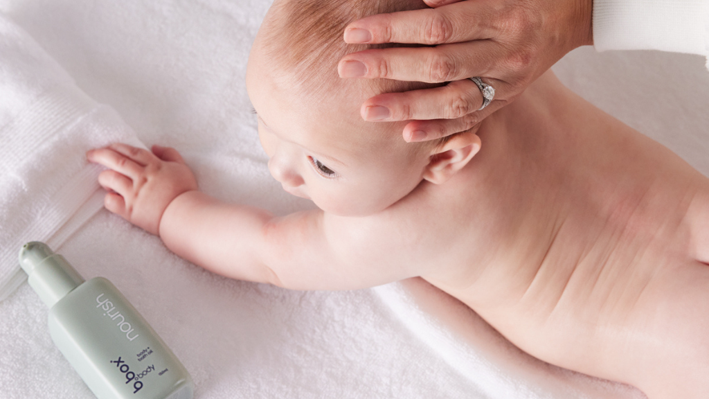 parent gives child a baby massage using b.box body nourish oil