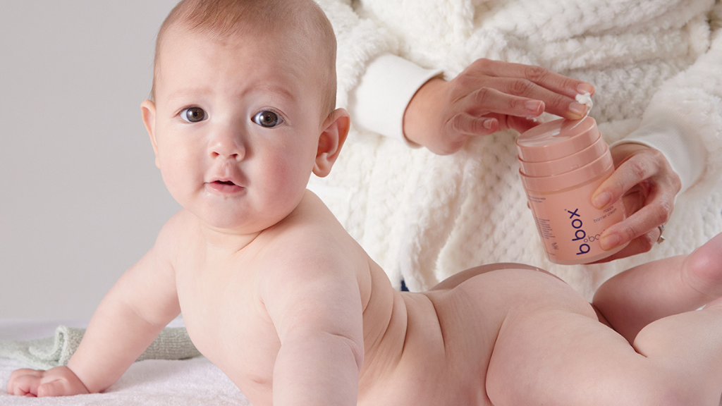 parent applying b.box body protect on their baby with sensitive skin