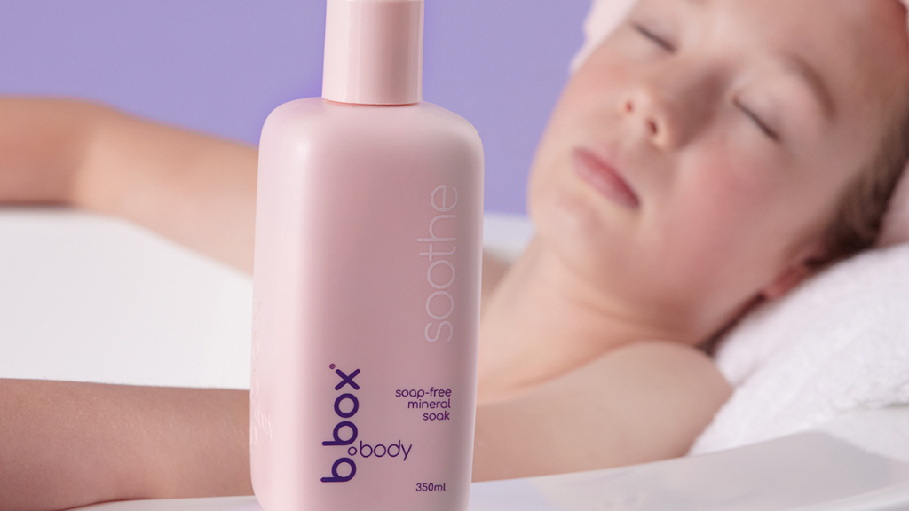 young child sits in bath with b.box soothe soap-free mineral soak