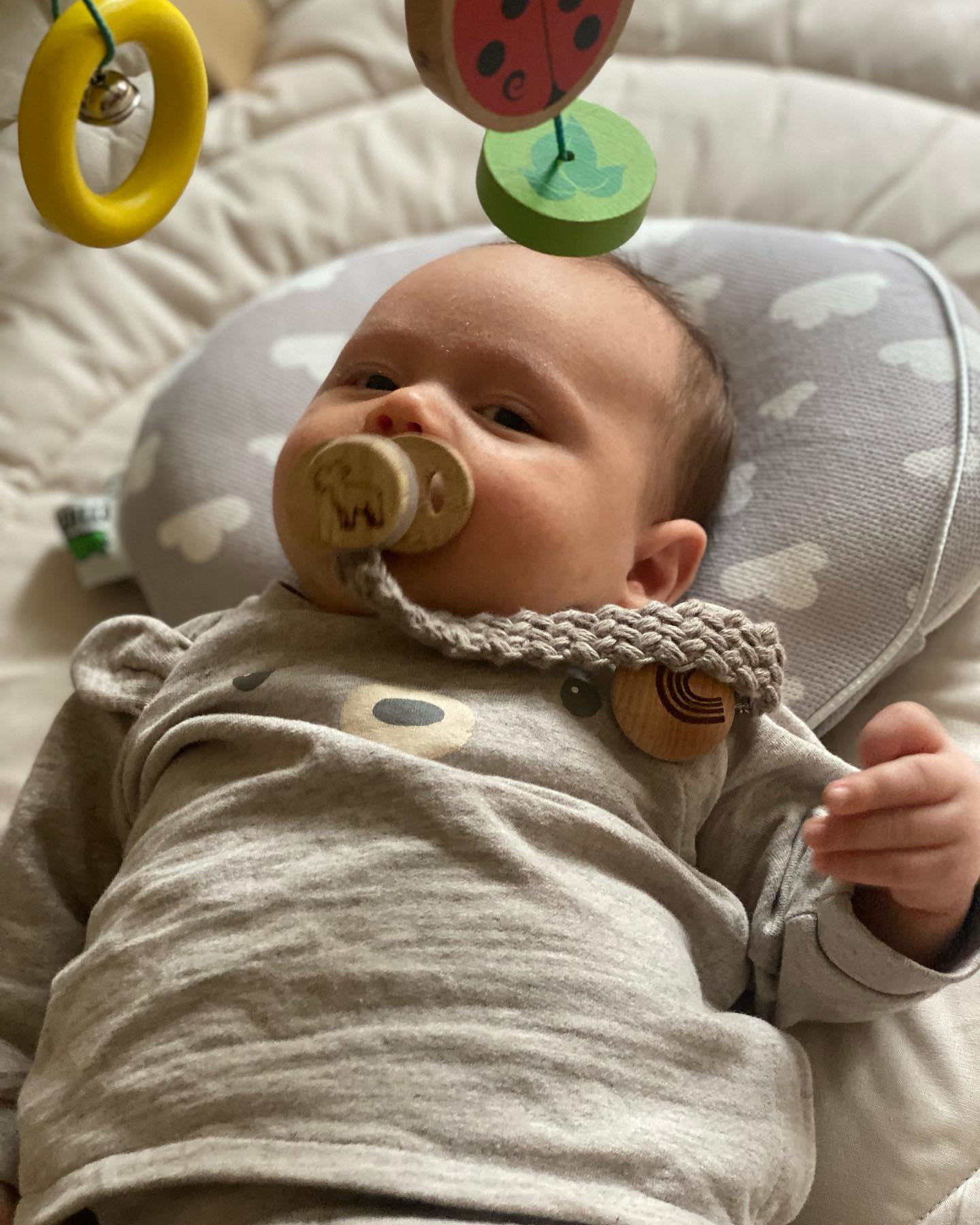 Baby holding TinyMarks Bamboo pacifier
